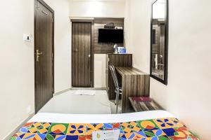孟买Hotel Horizon的小房间设有床铺和电视