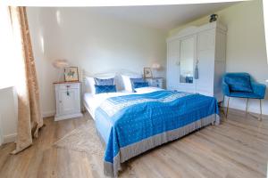 伊普霍芬DAS KLEINE HOTEL IPHOFEN, Iphofens kleines Secret的一间卧室配有蓝色的床和蓝色椅子