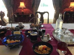 BallyraggetGrange Manor的餐桌,带食物盘和一瓶葡萄酒