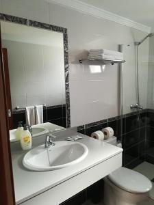 卡门港Gabiete的一间带水槽、卫生间和镜子的浴室