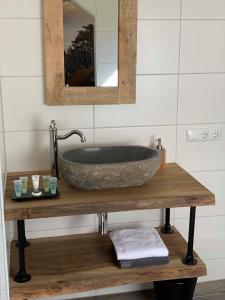 维里Brasserie de Peperboom的木桌上设有石制水槽的浴室