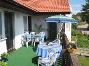 KarninHaus am Haff的一个带桌子和遮阳伞的庭院