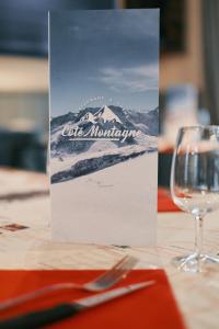 弗朗科尔尚斯帕皮乐旅舍的一张桌子,上面放着酒杯,上面有一块标志,上面写着一个山