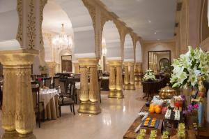 斋浦尔Jai Mahal Palace的一间带桌椅和吊灯的用餐室