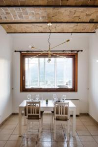 切拉诺LaVistaDeiSogni Palmarette的一间设有白色桌椅和窗户的用餐室