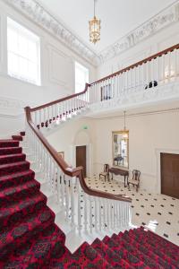 都柏林Henrietta Suites City Centre的白色房间的一个楼梯,铺有红色地毯