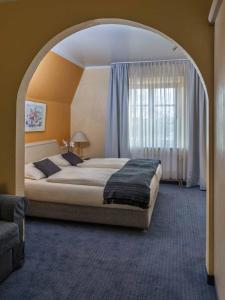 韦瑟灵蓬蒂维酒店的拱门上的卧室配有一张大床
