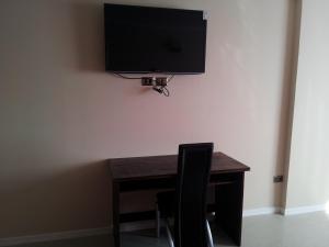 安托法加斯塔阿斯特瑞套房酒店的一张桌子、椅子和墙上的电视