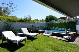 阿尔卡彼得克Estoril Garden Villa - 4Bedroom private pool - CheckinHome的后院设有两把椅子和游泳池