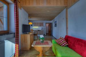 里茨勒恩麦克拉费伦-舒罗斯勒酒店的客厅配有绿色沙发和桌子