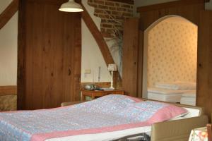 BocholtzHof Kricheleberg的一间卧室设有一张床和一个拱形窗户