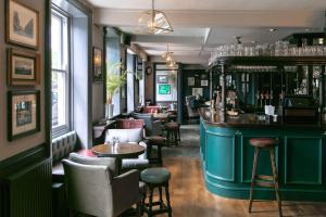 伦敦玫瑰与皇冠酒店的一间酒吧,在房间内配有桌椅