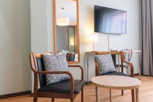 艾内科斯基麋鹿酒店的一间设有两把椅子、一张桌子和一面镜子的房间