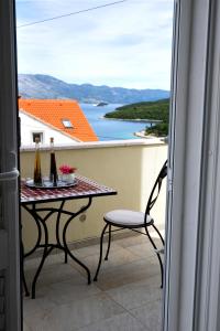 科尔丘拉Bella Vita的阳台配有桌子和2瓶葡萄酒