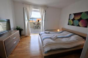 科尔丘拉Bella Vita的一间卧室配有一张床、一台电视和一个阳台