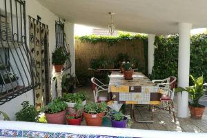 塔拉韦拉·德·拉·雷纳Casa de Campo Talavera的一个带桌子和一束盆栽植物的庭院