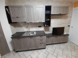 卡坦扎罗Casa LuLù的一间带木制橱柜和水槽的厨房以及一台电视。
