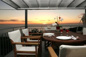 雅莎尼奥Pure Blue的阳台上的一张桌子和酒杯,享有日落美景
