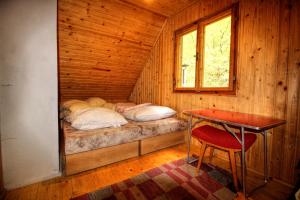 Spišské Tomášovce查塔泽拉塔克度假屋的小木屋内的小卧室配有一张床