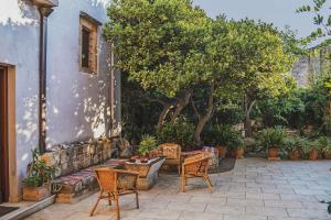 KambánionIconic Cretan Stone Mansion的庭院配有桌椅和树木