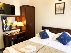 扎科帕内Hotel Patria Zakopane Centrum的酒店客房,设有两张床和镜子