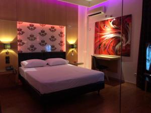 比雷埃夫斯奥林匹克酒店的一间卧室配有一张紫色照明床