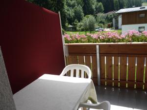坎波图雷斯Hörtmairhof的鲜花阳台的白色桌椅