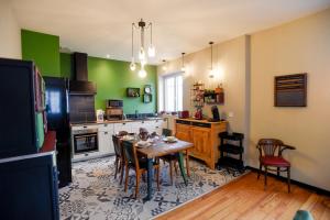 巴涅尔德比戈尔L'EN VERT的厨房配有桌椅和绿色的墙壁