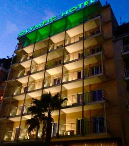 比雷埃夫斯奥林匹克酒店的建筑的一侧有绿色标志