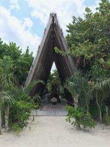 图卢姆图卢姆泊克娜酒店的三角形的建筑,有树木和海滩