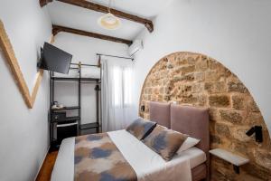 罗德镇卡萨德拉瑟拉酒店的一间卧室设有一张床和砖墙
