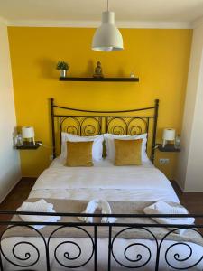 阿尔莫格拉维Al Casa Paquito的一间卧室设有一张黄色墙壁的大床