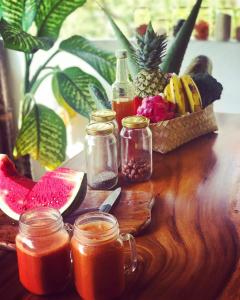 金巴兰Balangan Inn Surf Homestay的一张木桌,上面放着一罐果汁和一篮水果