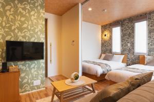 佐世保Ambicia Sasebo的酒店客房设有两张床和一台平面电视。