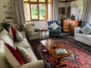 哈士汀Hawkes Bay Villa-Beechwood的客厅配有沙发、椅子和桌子
