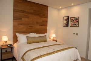 Santa Cruz TecamacHotel Verticca的一间卧室配有一张大床和木制床头板