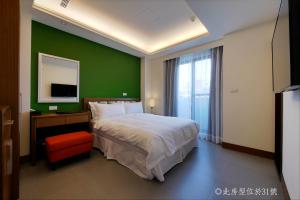 高雄碧港良居商旅-西子湾 的一间卧室设有一张大床和绿色的墙壁