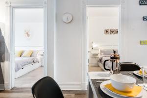 蒙特利尔Apartments Near Montreal Olympic Park的白色的客房配有一张床和一张桌子及椅子