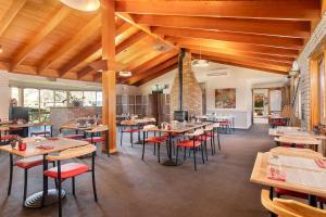 沃加沃加卡里奇豪斯品质酒店的餐厅设有木制天花板和桌椅