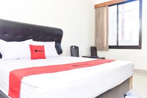 沃诺索博RedDoorz near Alun Alun Wonosobo的一间卧室配有一张带红色枕头的大床