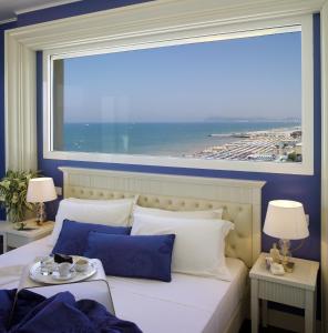 里乔内蒂法尼酒店的卧室设有大窗户和一张大床
