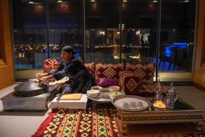 科威特棕榈海滩温泉酒店的坐在餐桌旁吃着食物的女人