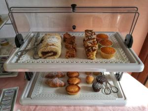 奥特朗托Podere San Luigi Residence的装有不同种类糕点和松饼的展示盒