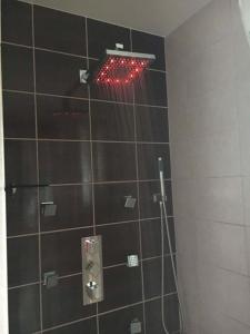 克雷廷加Garaseta的墙上设有红色灯光和淋浴的浴室