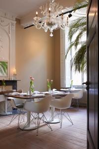 马斯特里赫特沙尔莫斯酒店的一间带桌椅和吊灯的用餐室