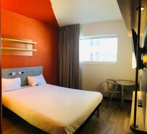 蒙特勒伊巴黎 波特蒙特勒伊德宜必思快捷酒店的一间卧室配有一张橙色墙壁的床