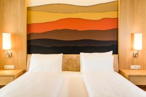卡尔达罗哈斯霍夫酒店的一间卧室设有两张床,墙上挂着一幅画