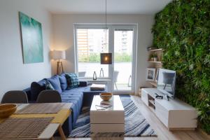 布拉迪斯拉发Spacy Modern Apartment near Hockey Stadium的客厅设有蓝色的沙发和绿色的墙壁