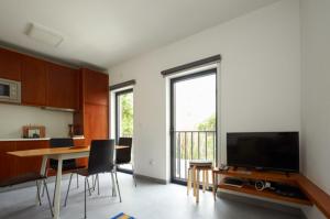 埃里塞拉Pedra Branca Apartments的客厅配有桌子和大屏幕电视