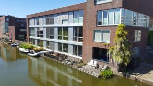 阿姆斯特丹The Water Studio的河边的建筑物,里面装有船只